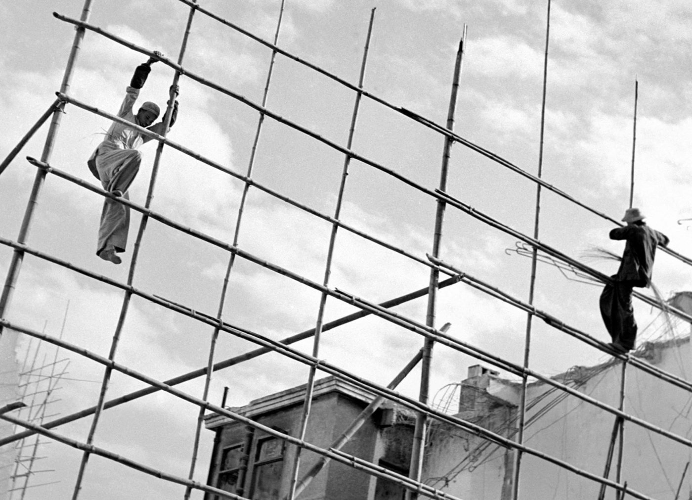 Bamboo Men, de Fan Ho, 1956 — dois trabalhadores em silhueta sobre um andaime de bambu contra o céu